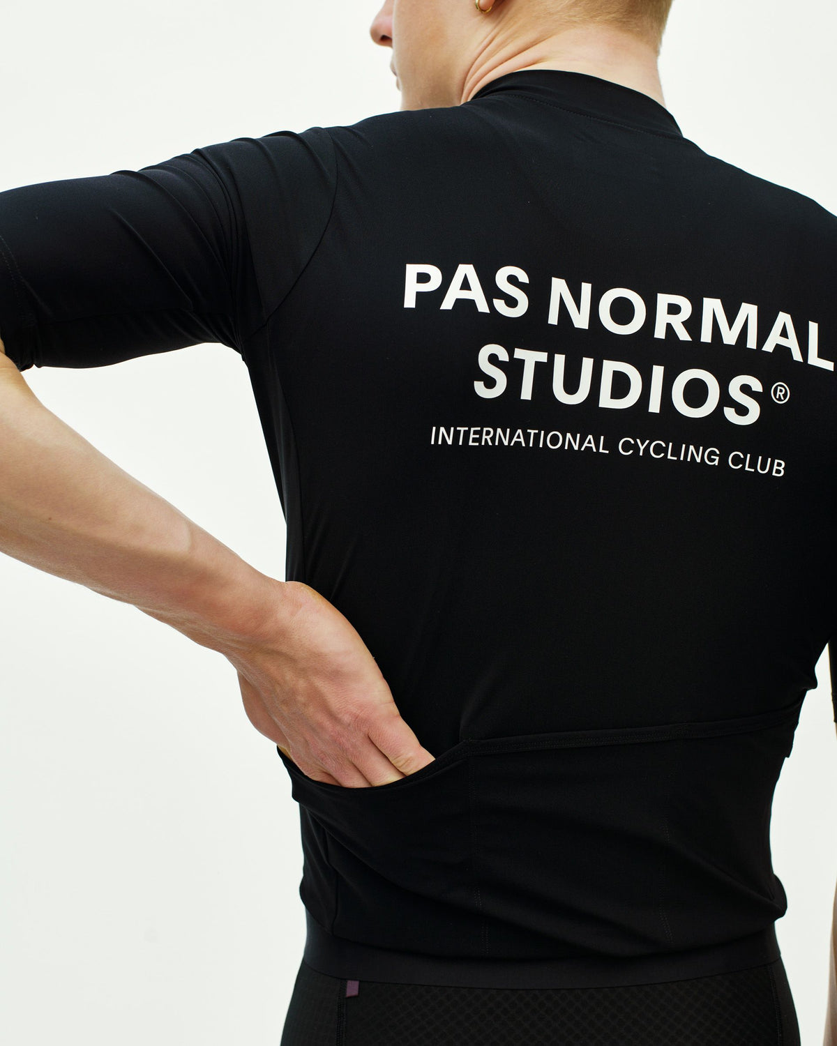 Maillot Corto Pas Normal Studios Essential en Black, detalle sobre ciclista #Color_Black