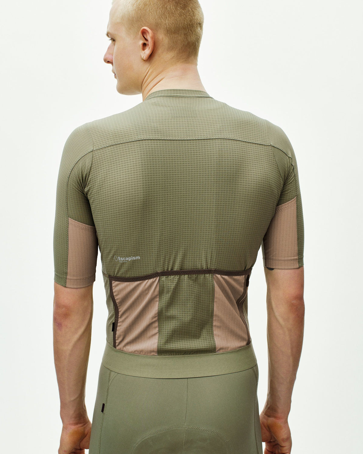Maillot Corto Pas Normal Studios Escapism en Light Olive, vista trasera sobre ciclista #Color_Light Olive