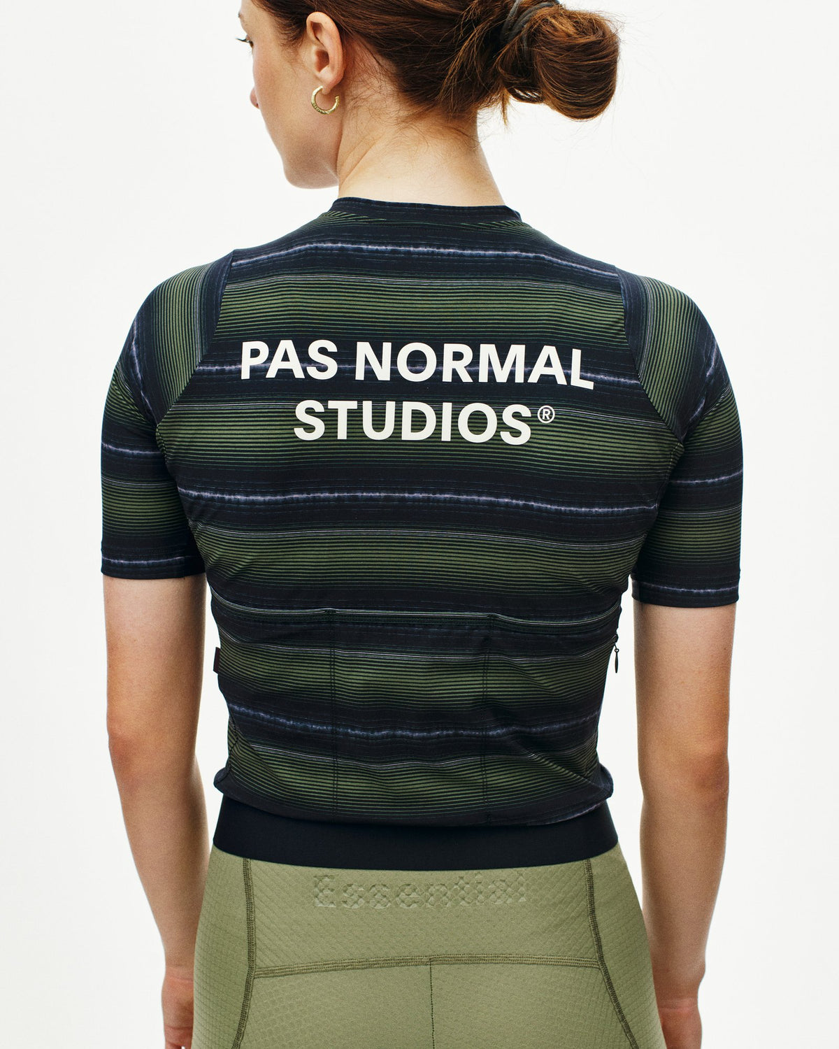 Maillot corto de mujer Pas Normal Studios Essential en Light Olive Stripe, vista trasera sobre la ciclista #Color_Light Olive Stripe