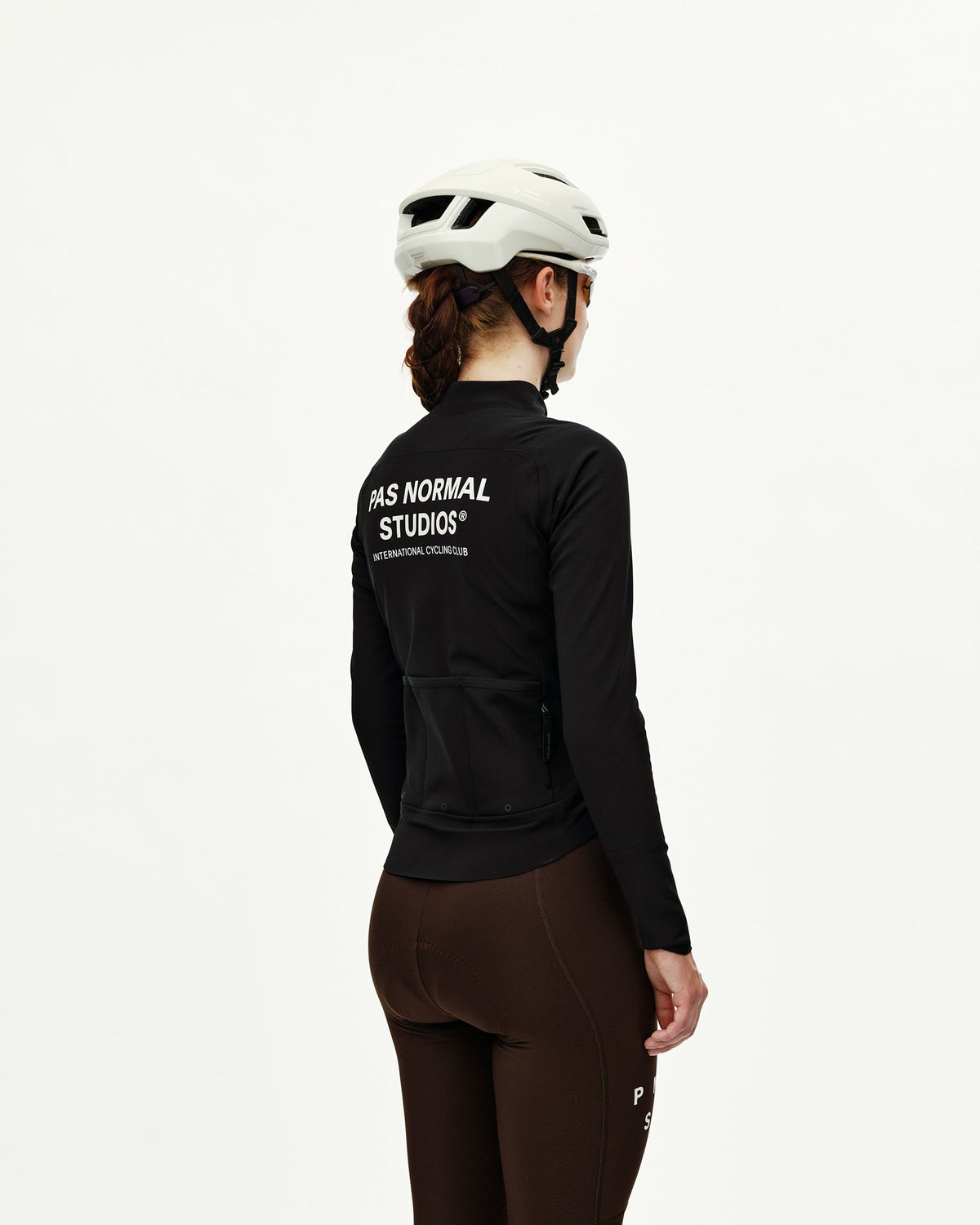 Black Mechanism Thermal women's cycling jacket on model, rear view with white back logo print and rear pockets #Color_Black