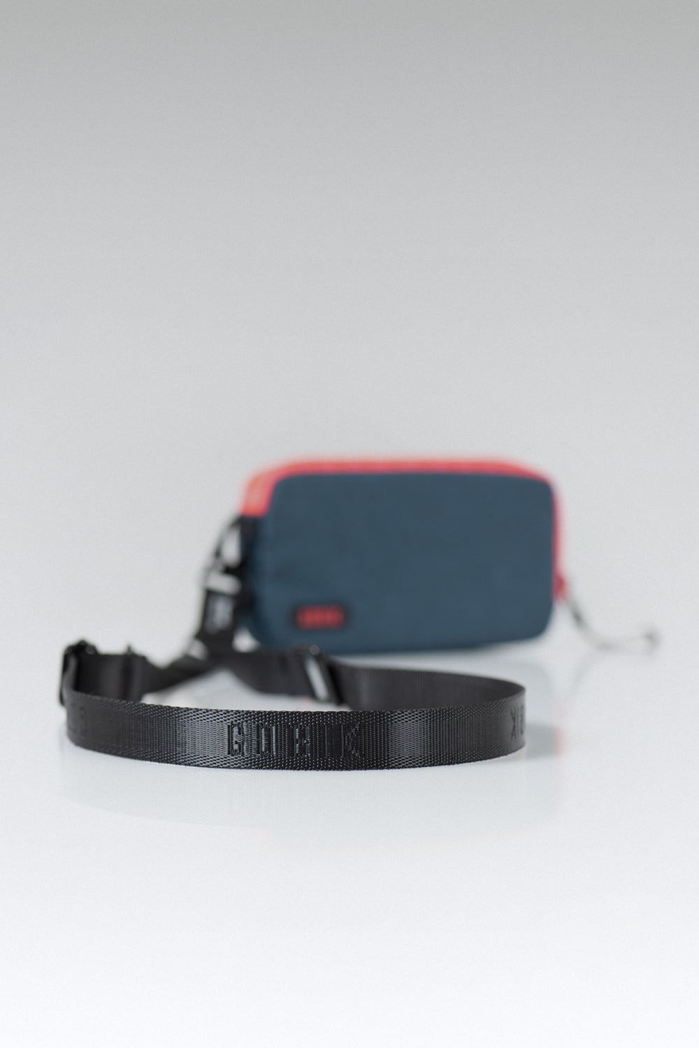 Correa Regulable Gobik Essential en True Black, correa enrollada junto a la funda de móvil Essential #Color_True Black