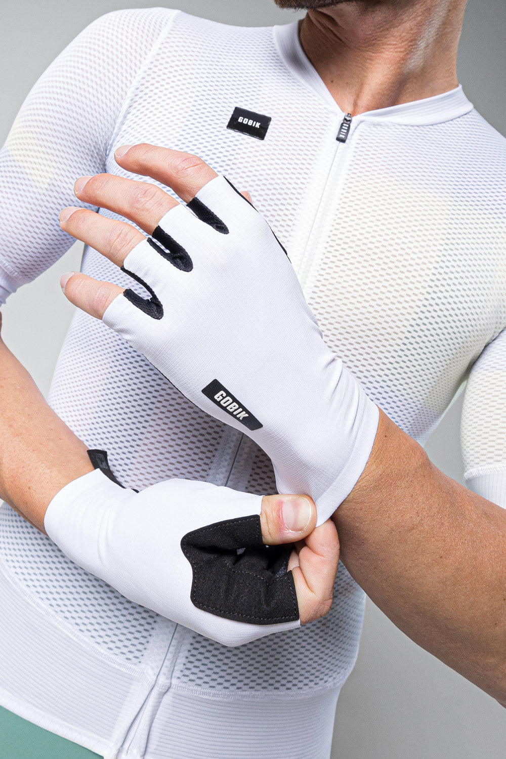 Guantes Gobik Mamba 2.0 en White, detalle del dorso del guante mientras el modelo se lo ajusta #Color_White