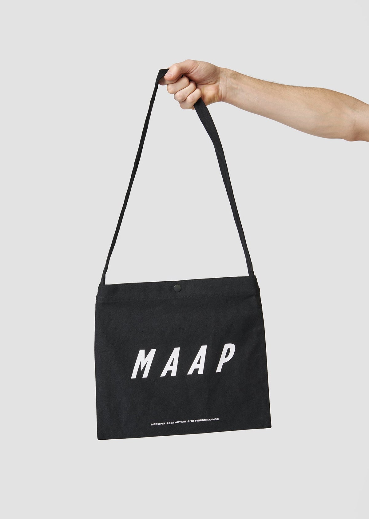 Bolsa MAAP Musette en Black, sujeta por la bandolera #Color_Black