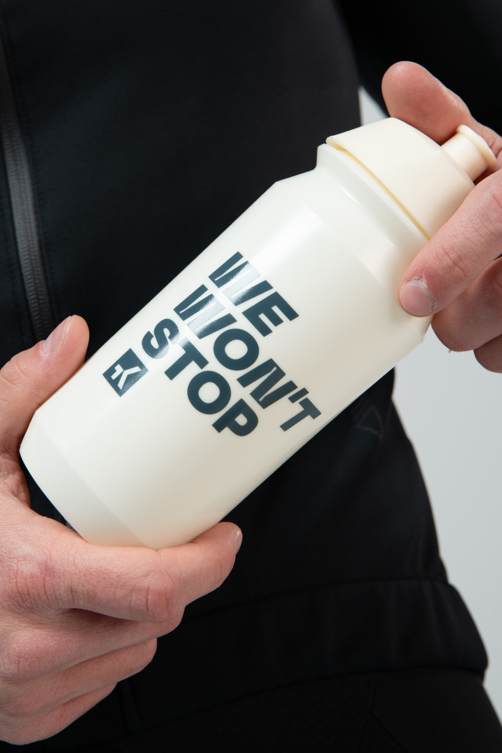 Bidón Gobik Shiva en Ivory (Bio), manos sujetando el bidón crema con el lema WE WON'T STOP #Color_Ivory (Bio)