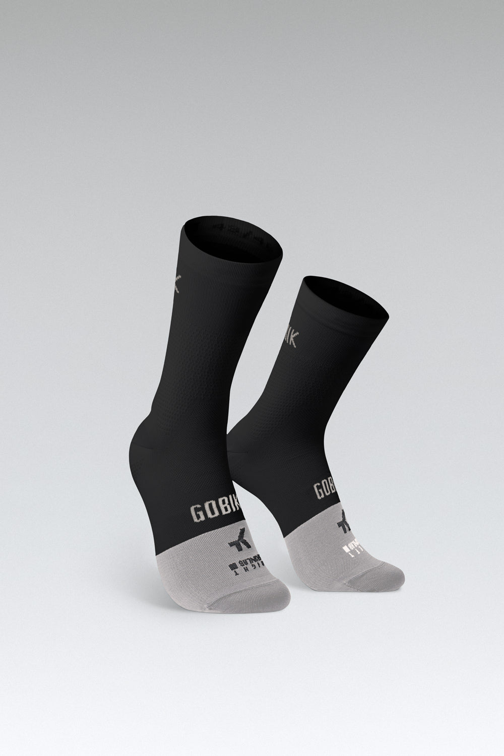 Calcetines Gobik Lightweight 2.0 en Jasper, bodegón del par de calcetines negros con el pie gris sobre fondo de estudio #Color_Jasper