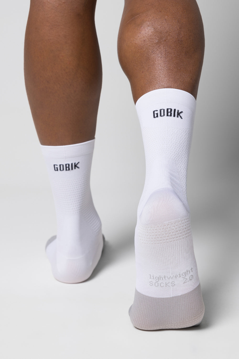Calcetines Gobik Lightweight 2.0 en Salt, vista trasera de las piernas del modelo con los calcetines blancos puestos #Color_Salt