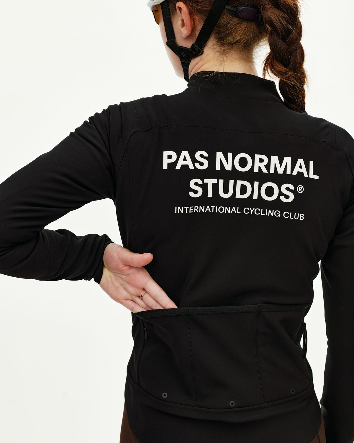 Black Mechanism Thermal cycling jacket on model, rear view with white back print and rear pockets #Color_Black
