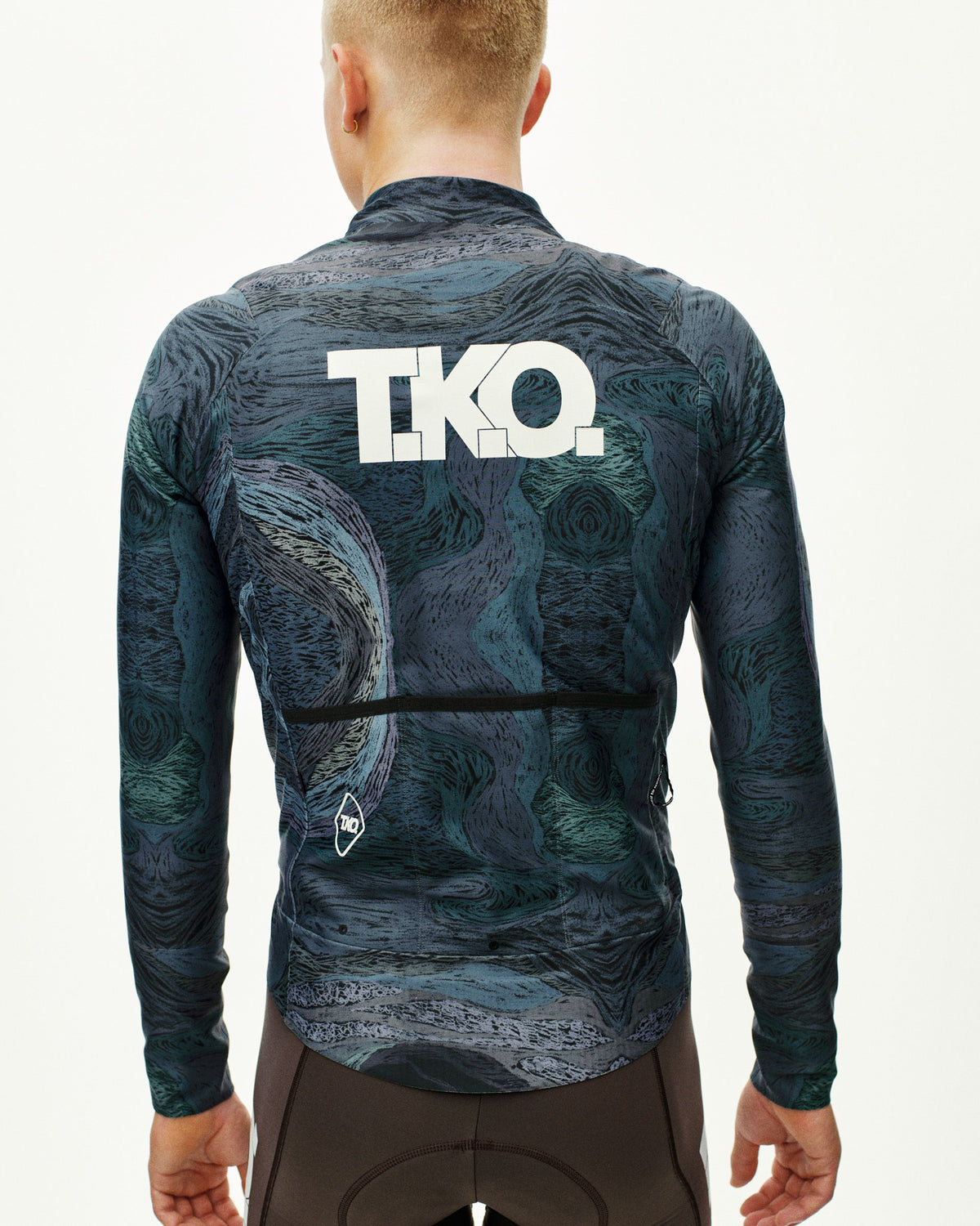 Dark Multi T.K.O. Mechanism Thermal cycling jacket on model, rear view with allover swirl print and white T.K.O. back logo #Color_T.K.O. Dark Multi