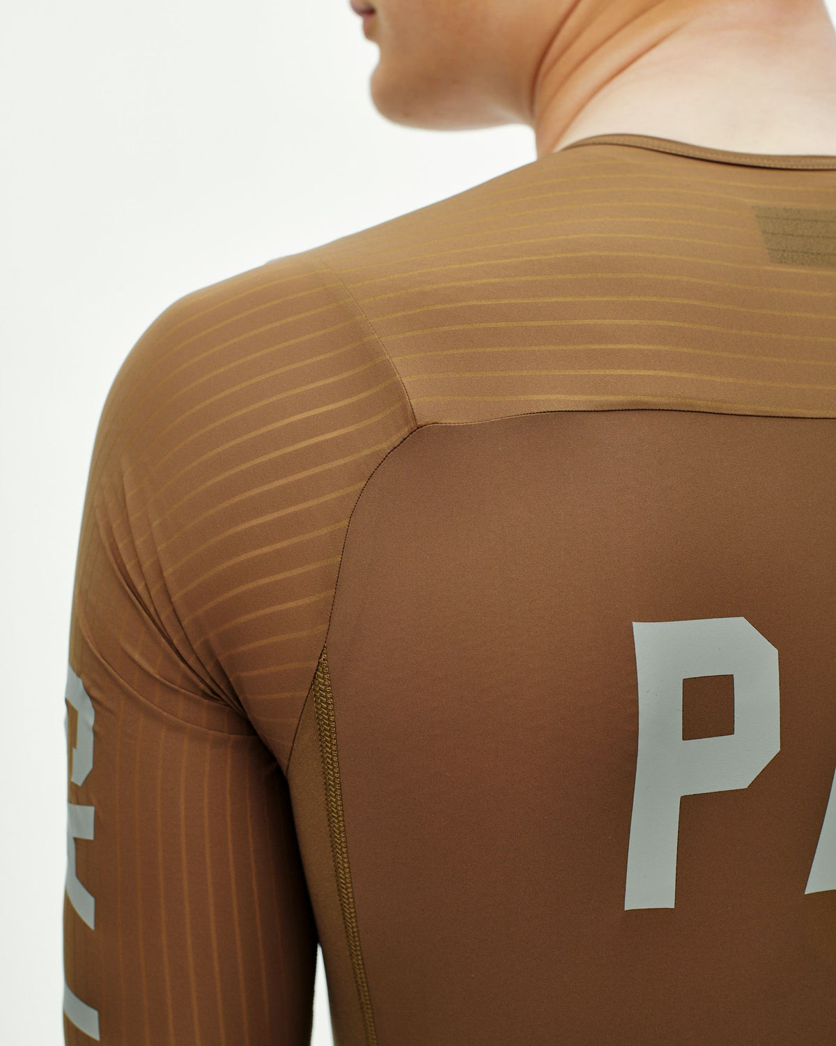 Brown PAS Mechanism Pro speedsuit on model, rear three-quarter view with ribbed shoulder panels #Color_Brown