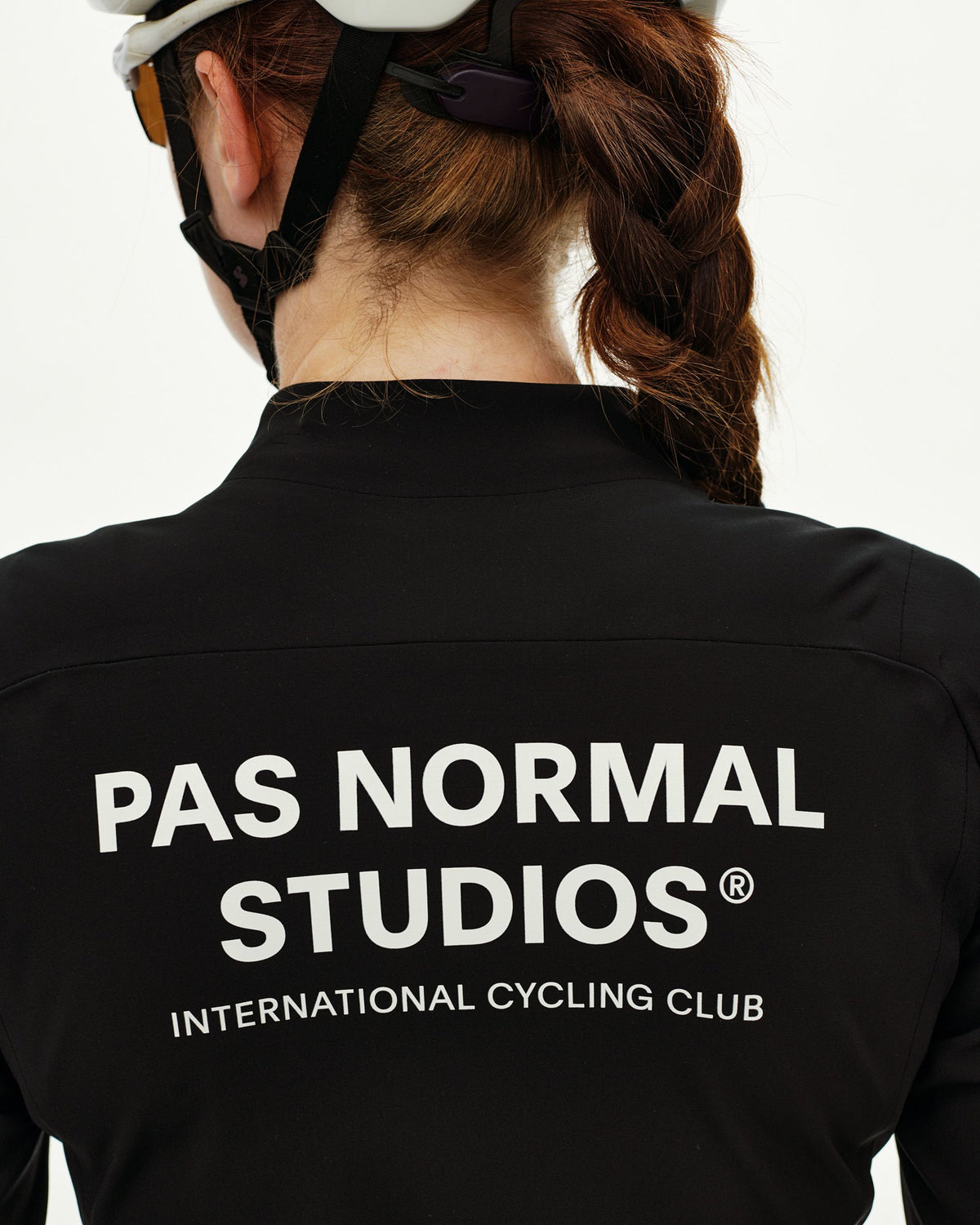 Black Mechanism Thermal cycling jacket on model, rear view with white logo print across back #Color_Black