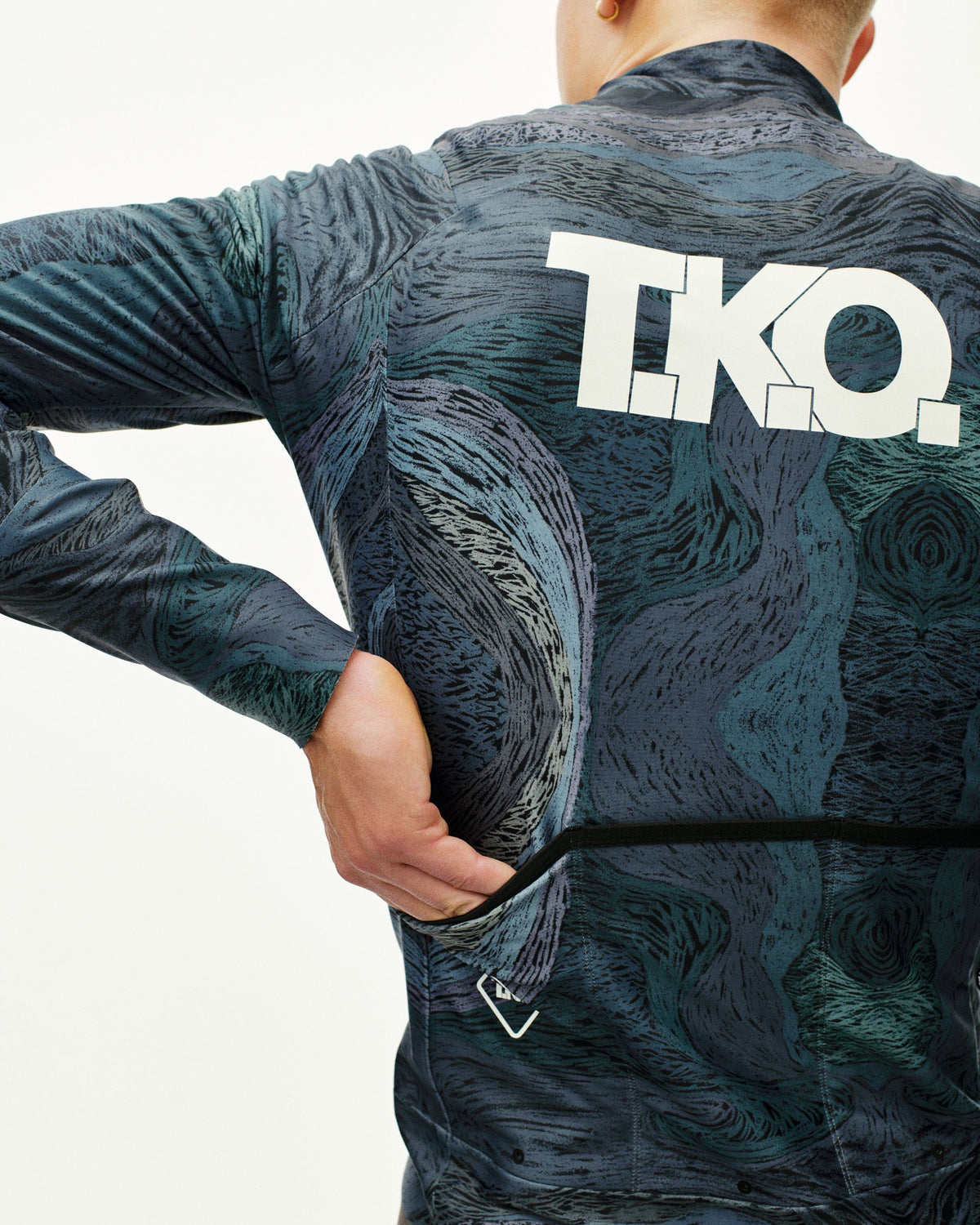 Dark Multi T.K.O. Mechanism Thermal cycling jacket on model, rear view with all-over print and back pocket #Color_T.K.O. Dark Multi