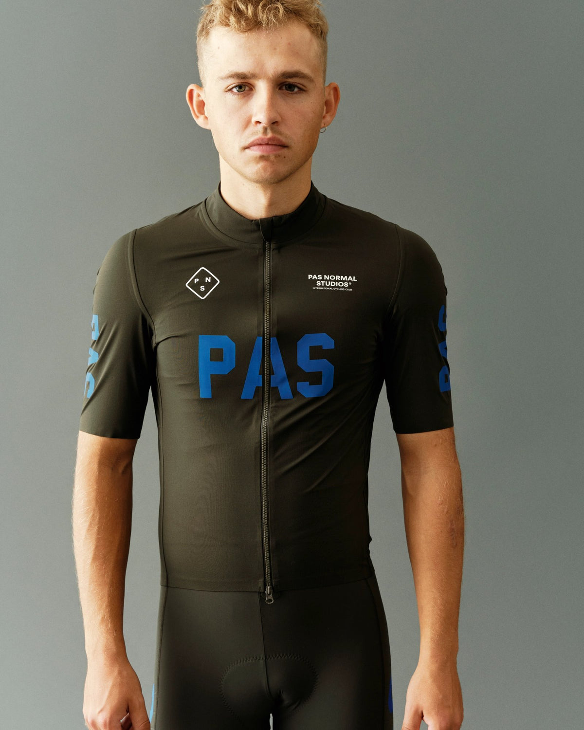 Maillot corto impermeable Pas Normal Studios PAS Mechanism Pro Rain en Dark Olive, sobre el ciclista #Color_Dark Olive