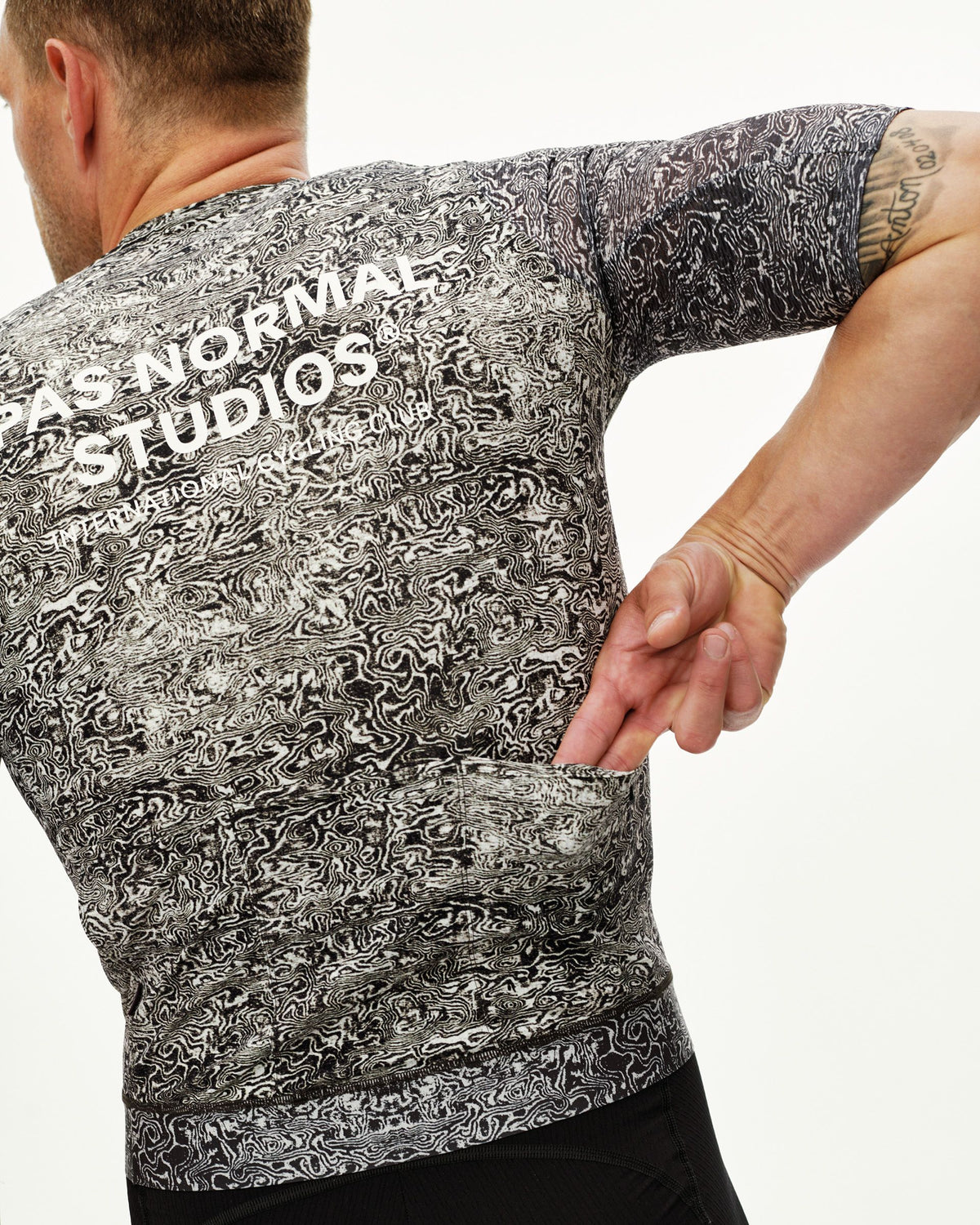 Maillot Corto Pas Normal Studios Essential Light en AOP Grain Off White, detalle sobre ciclista #Color_AOP Grain Off White