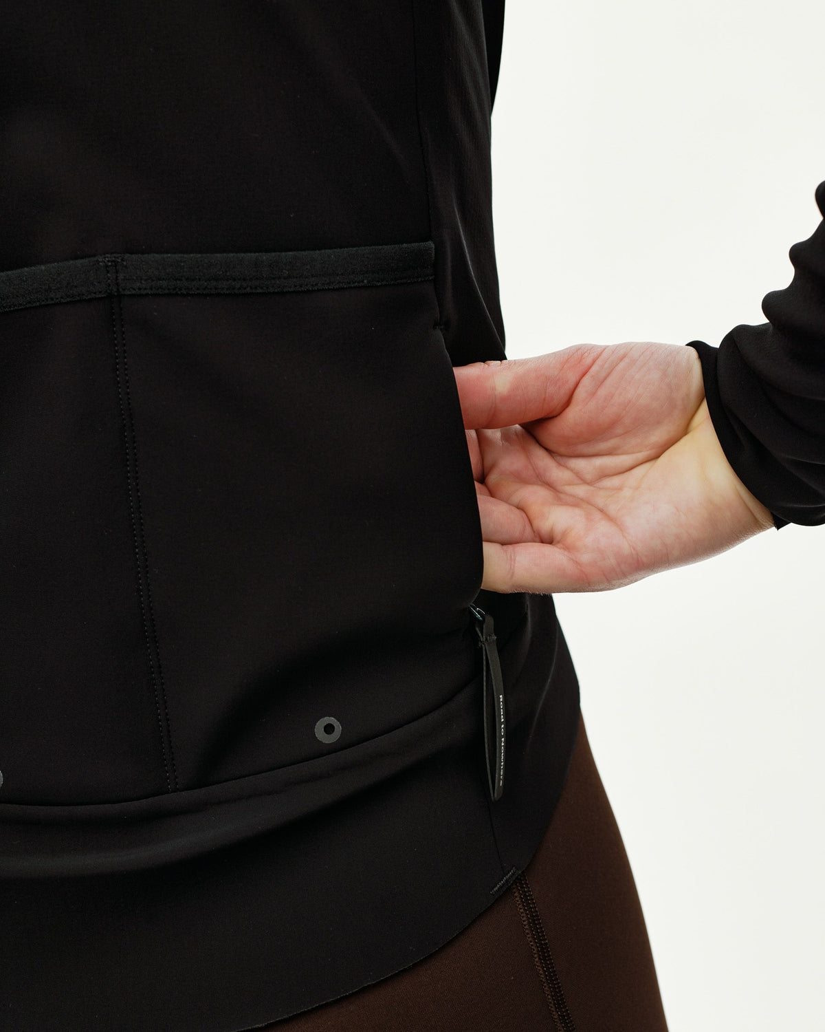 Black Mechanism Thermal cycling jacket, detail view on model showing rear pockets with zip pocket pull #Color_Black