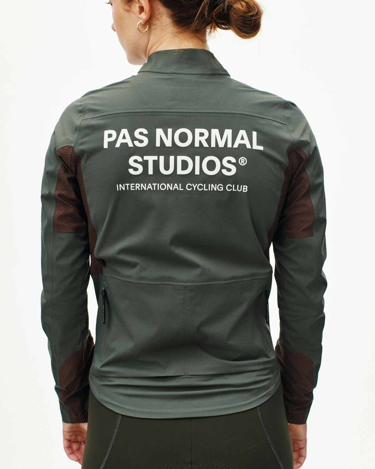 Dark Grey Mechanism Shell cycling jacket on model, rear view with white back logo and mesh side panels #Color_Dark Grey