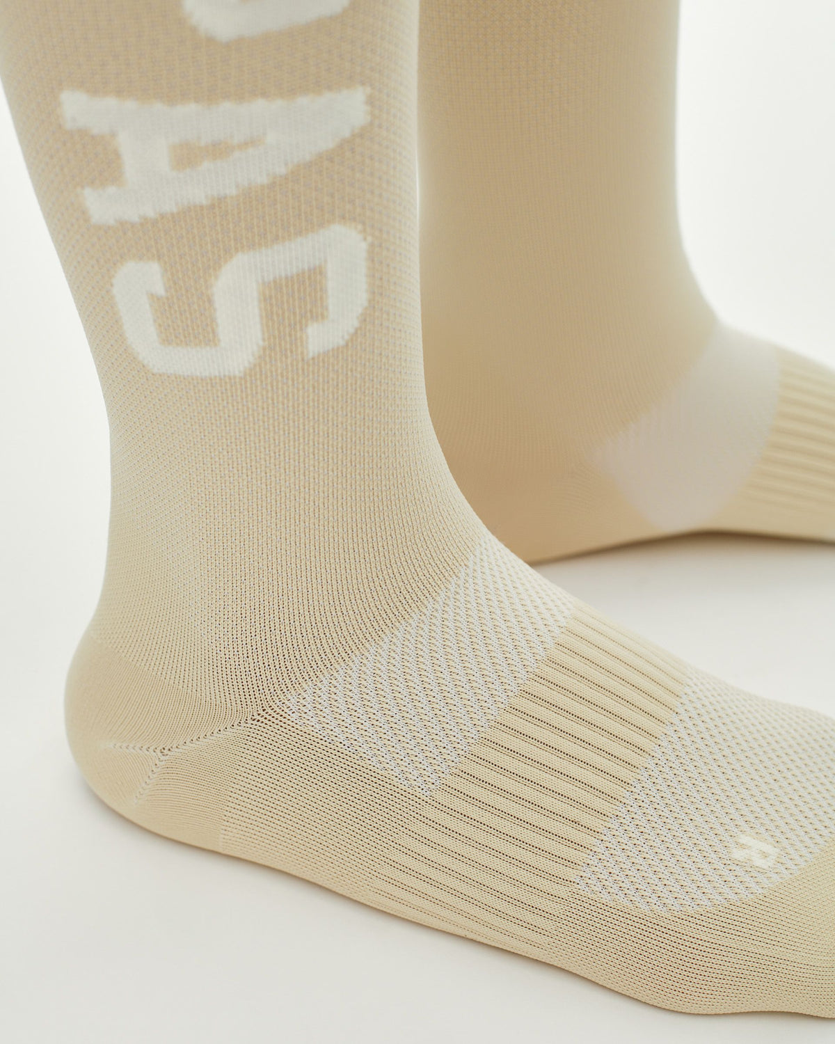 Cream PAS Race cycling socks, side view with white logo and ribbed cuff #Color_Cream