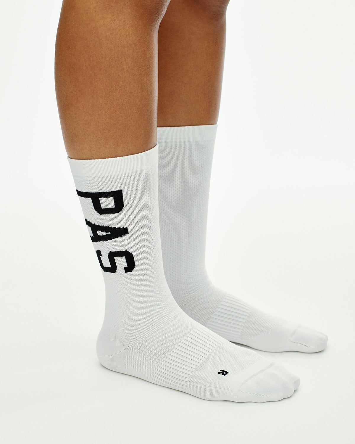 White PAS cycling socks on model with black vertical logo print #Color_White
