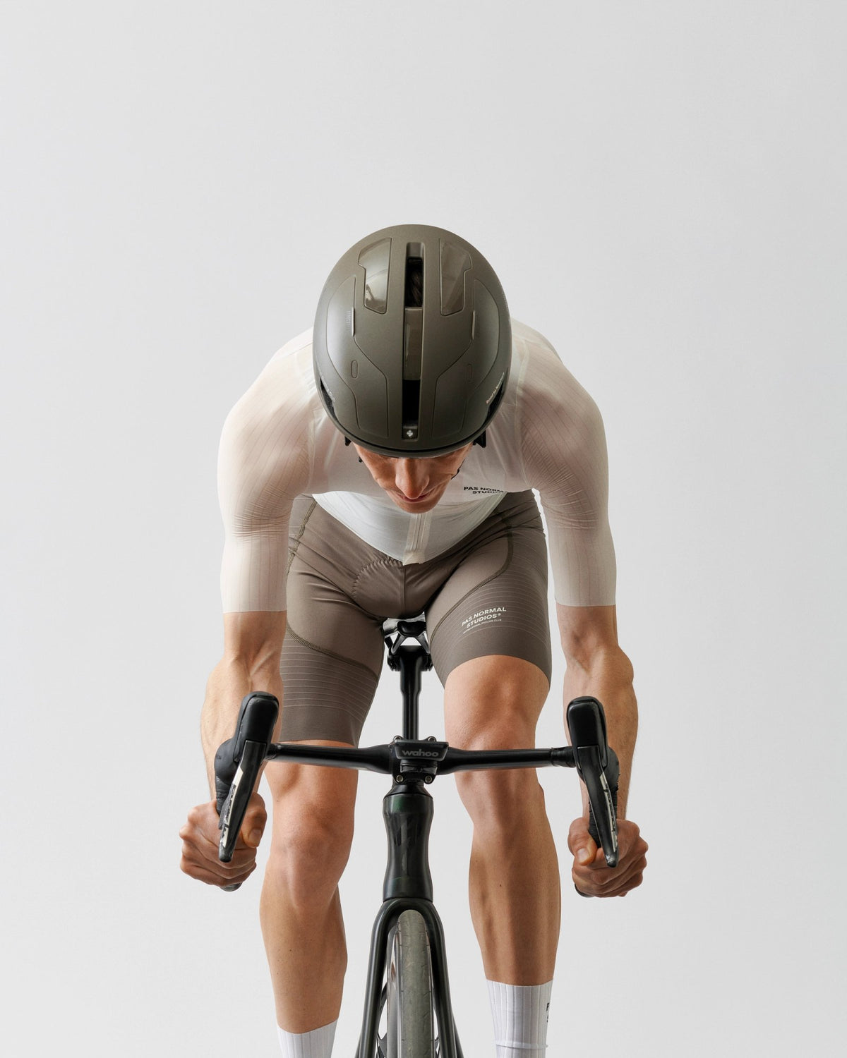 Culotte corto Pas Normal Studios Mechanism Pro en Earth, llevado por el modelo sobre la bici, vista frontal #Color_Earth