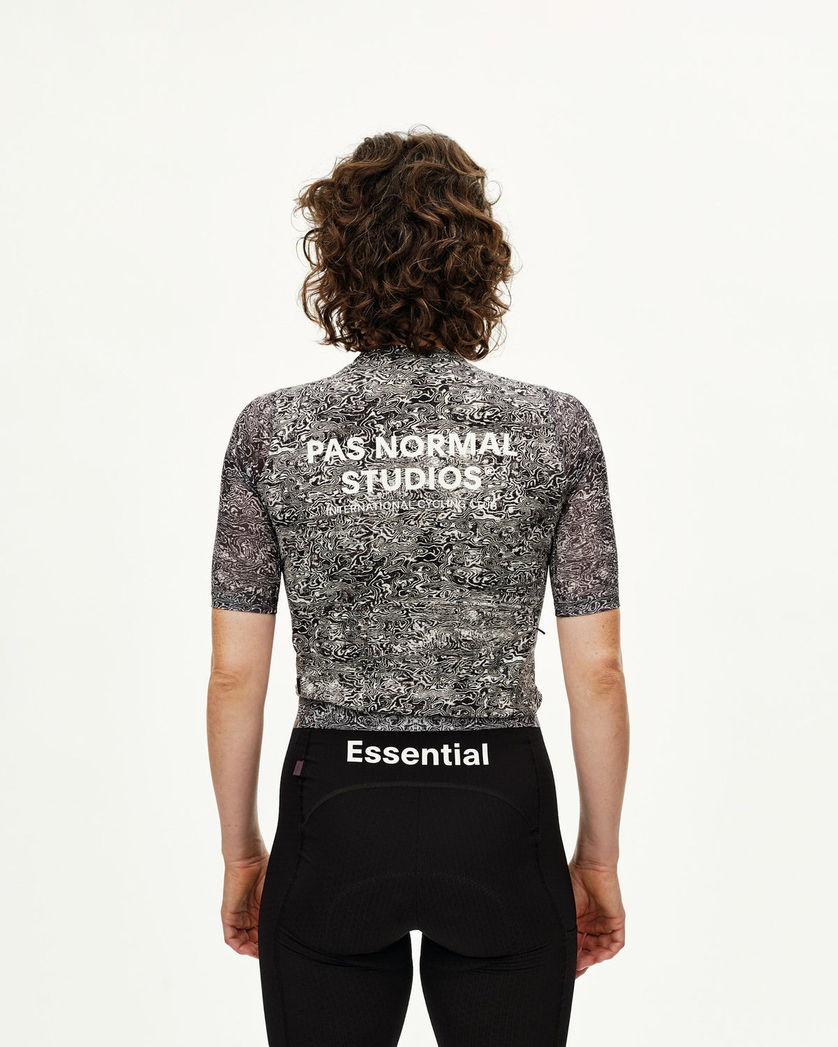 Maillot corto de mujer Pas Normal Studios Essential Light en AOP Grain Off White, vista trasera sobre la ciclista #Color_AOP Grain Off White
