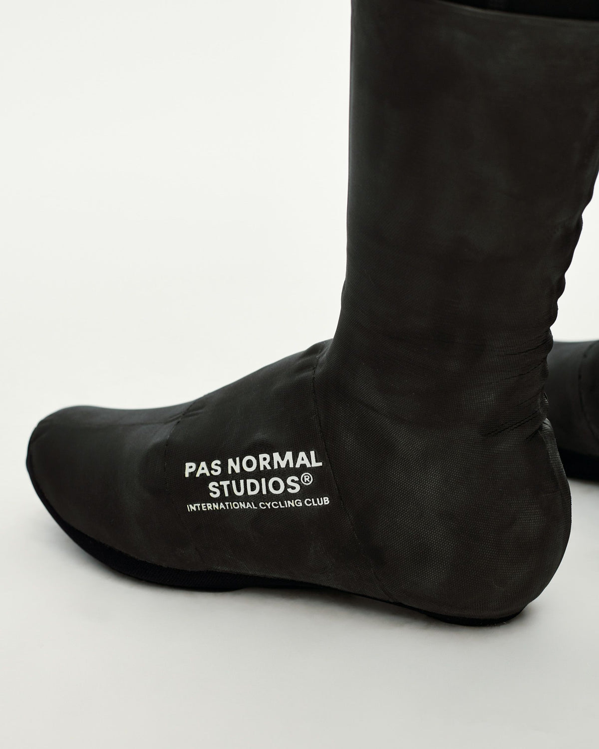 Black Logo Heavy cycling overshoes, three-quarter view on model with white chest logo print #Color_Black