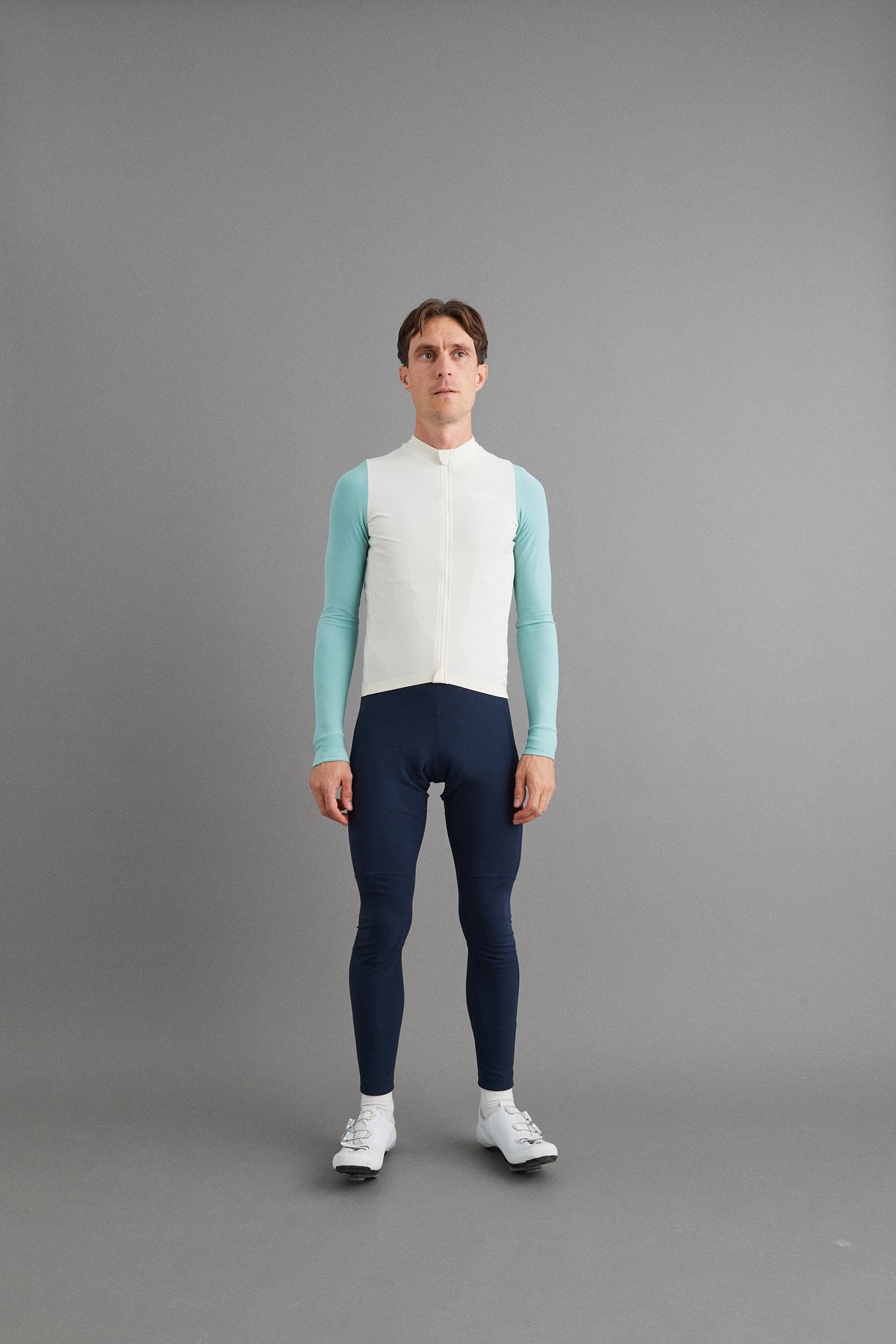 Maillot Largo Pas Normal Studios Mechanism en Off-White / Light Teal, sobre ciclista #Color_Off-White / Light Teal