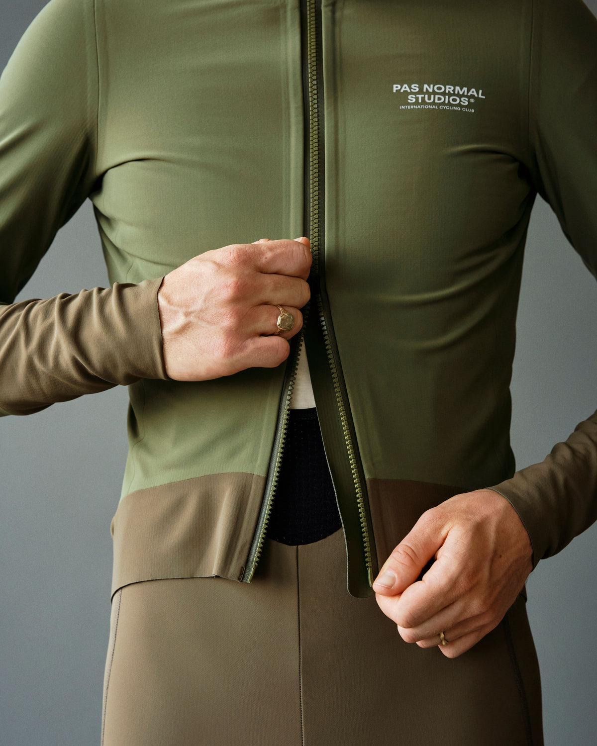Army Green Mechanism Thermal cycling jacket on model with contrast zip and hem panels #Color_Army Green / Dark Stone