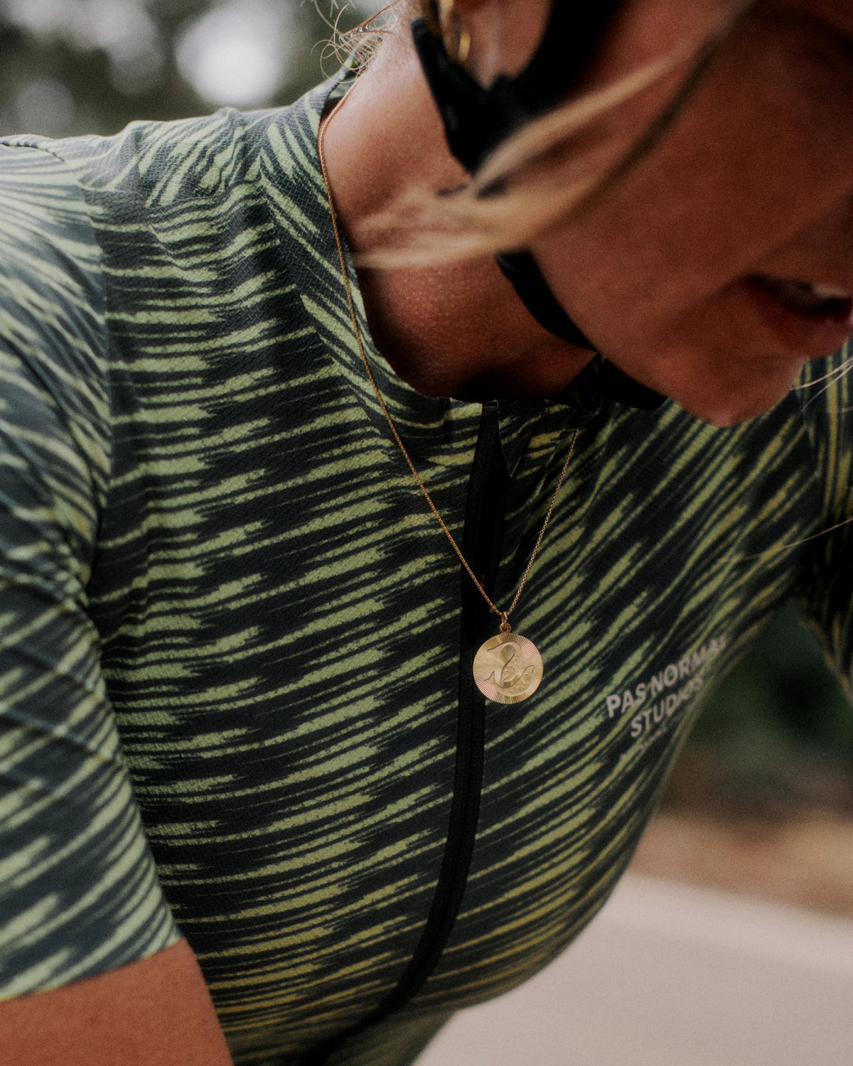 Maillot Mujer Pas Normal Studios Solitude en Dark Moss / Lime Green, sobre ciclista #Color_Dark Moss / Lime Green