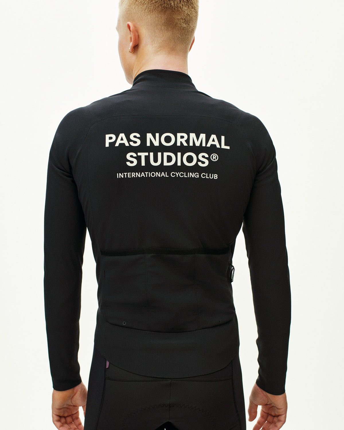Black Mechanism Thermal cycling jacket, rear view on model with white logo and back pockets #Color_Black