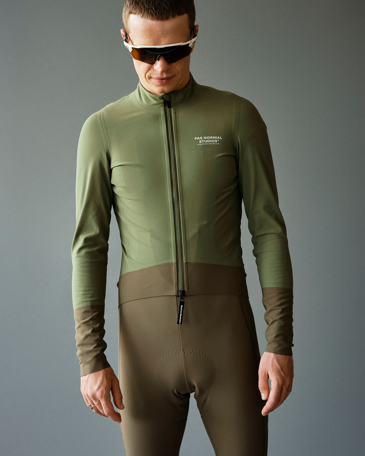 Army Green Mechanism Thermal cycling jacket on model with brown contrast lower panel #Color_Army Green / Dark Stone