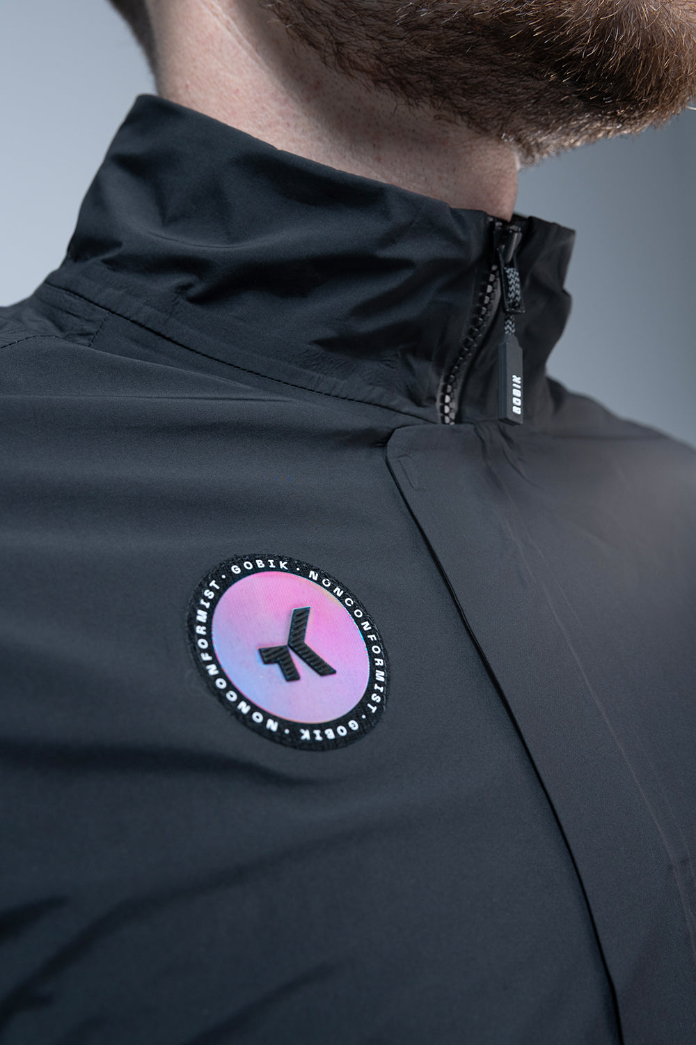 Chaqueta Gobik Superarmour en Royal Black, detalle del hombro con el emblema y el cuello elevado #Color_Royal Black