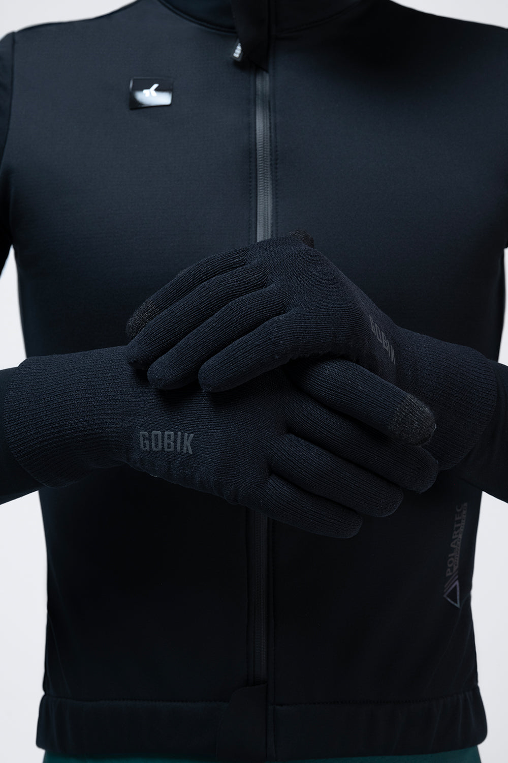 Guantes Gobik Hyperguard en True Black, detalle de las manos enguantadas cruzadas sobre el pecho #Color_True Black