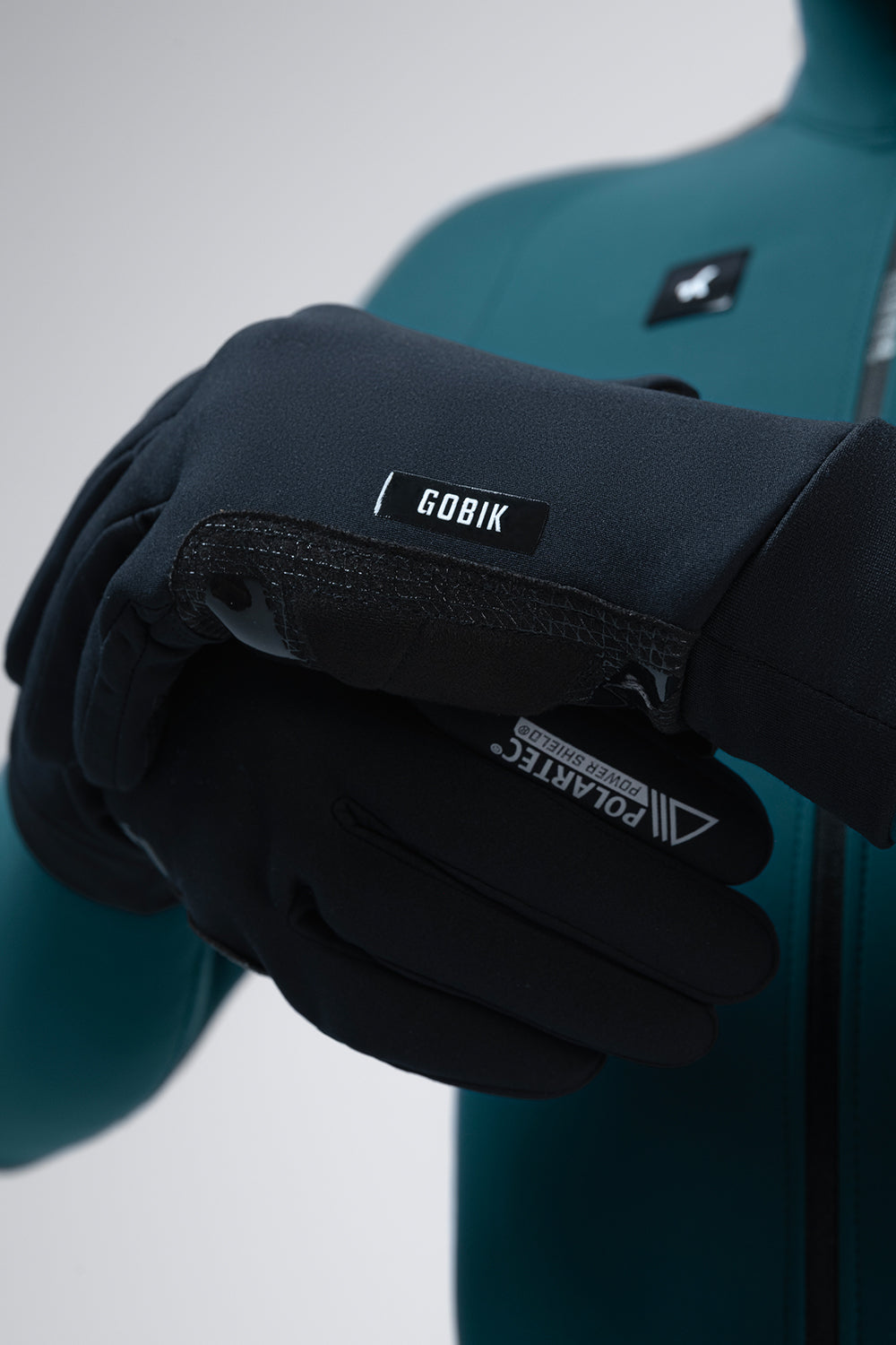 Guantes Gobik Bora 2.0 en True Black, detalle de las manos ajustando el puño de lycra del guante #Color_True Black