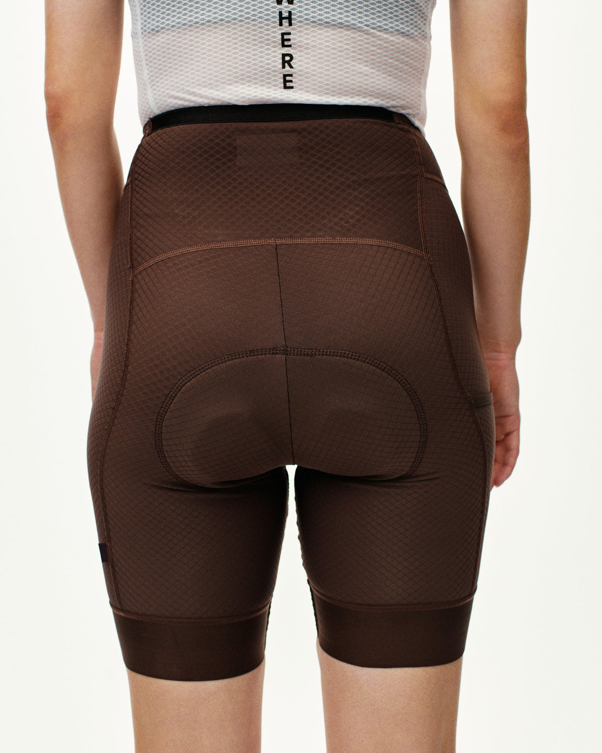 Mallas Cortas Mujer PNS Essential en Light Brown, sobre modelo de espaldas #Color_Light Brown