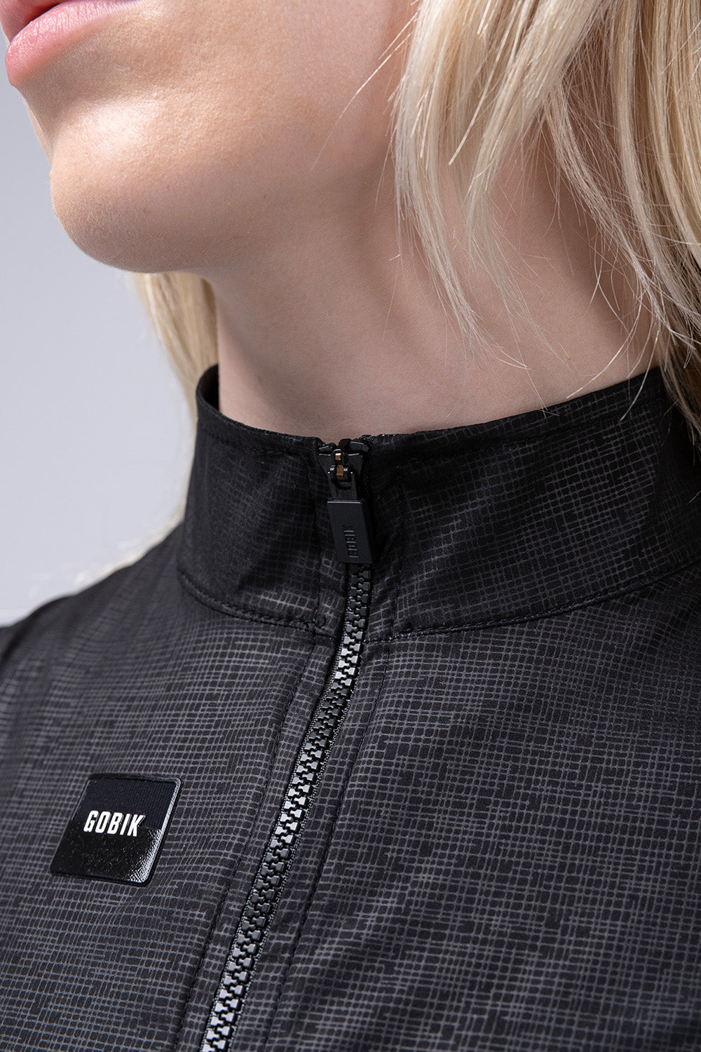 Chaleco Mujer Gobik Plus 2.0 en Blackcurrant, detalle del cuello elevado y el logotipo #Color_Blackcurrant