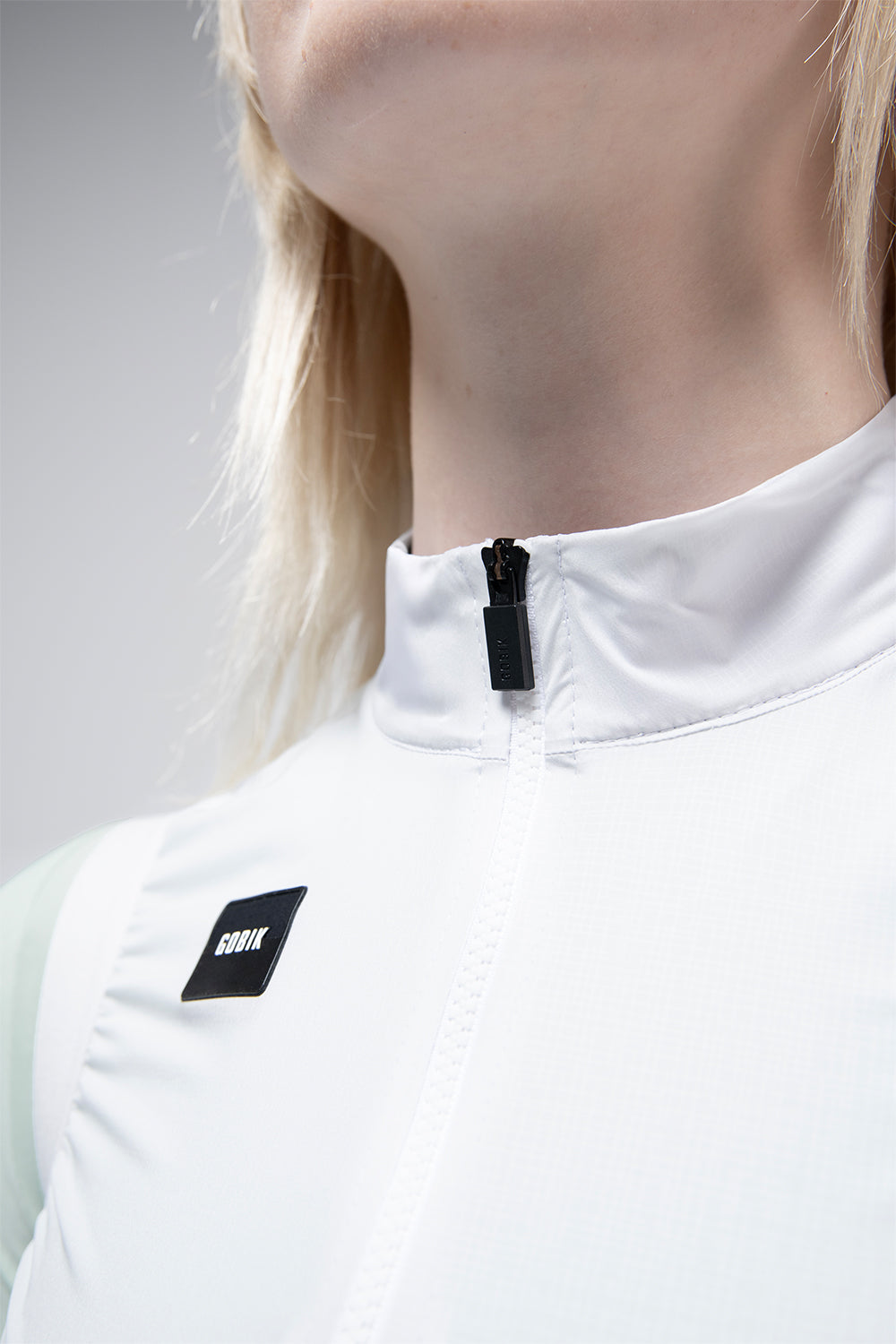 Chaleco Mujer Gobik Vector 2.0 en Athena, detalle del cuello elevado y el logotipo #Color_Athena